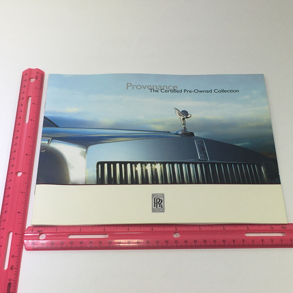 Front cover of the 2013 Rolls Royce Provenance Collection Brochure showcasing the iconic Rolls Royce hood ornament and luxurious setting.