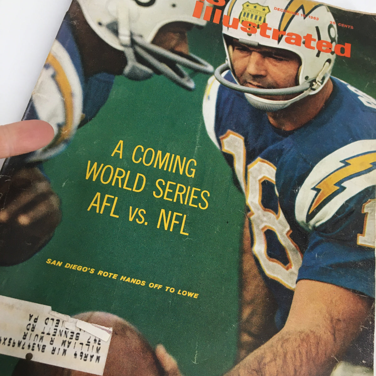 Close-up view of the cover of VTG Sports Illustrated Magazine December 16, 1963, featuring the caption 'A Coming World Series AFL vs. NFL' and a player in a football helmet.