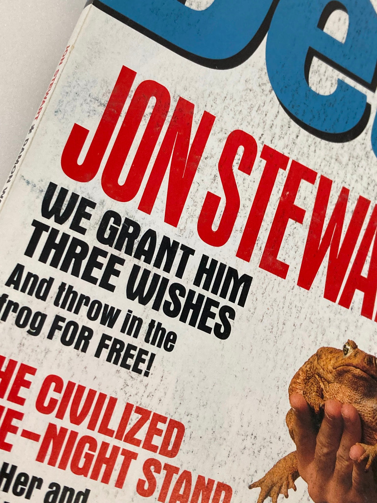 Detail of the headline 'We Grant Him Three Wishes' featuring Jon Stewart on the June 1999 cover of Details Magazine.
