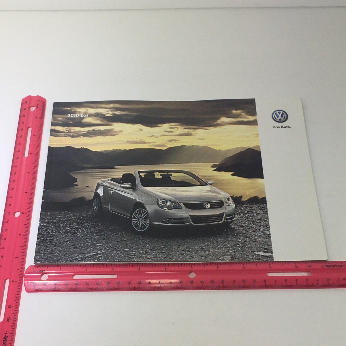 2010 Volkswagen Eos Dos Auto Dealership Car Auto Brochure Catalog displaying the front cover of the brochure with a silver Eos convertible against a stunning sunset backdrop, highlighting its elegant features.