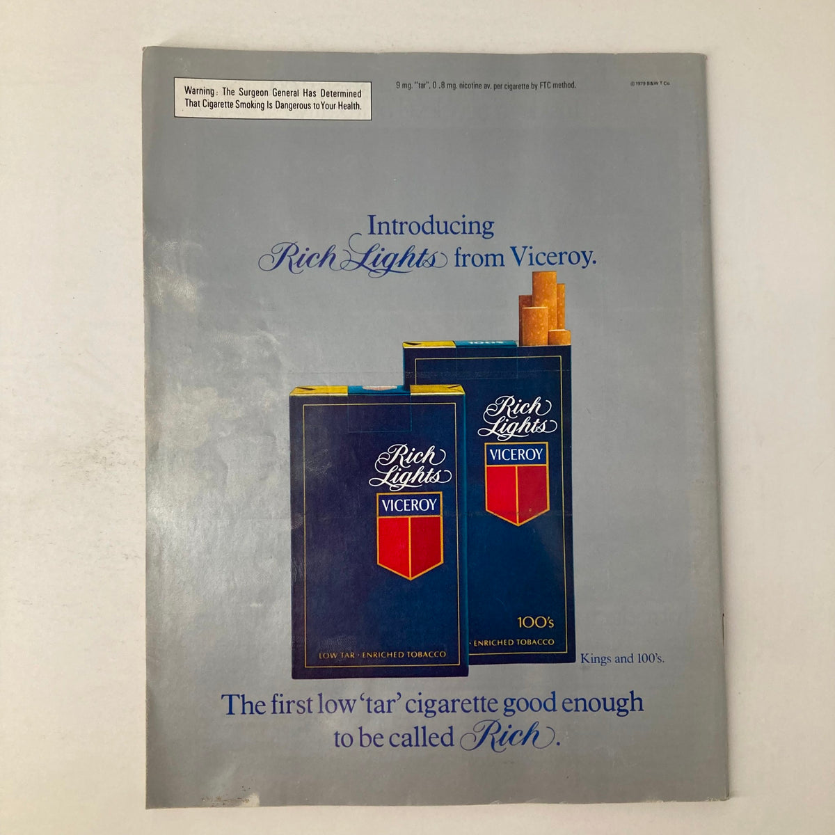 Vintage advertisement introducing Rich Lights cigarettes from Viceroy, featuring two packs on a grey background, showcasing the tagline on the bottom. This ad highlights the low tar, enriched tobacco cigarettes that were marketed as the first to be called 'Rich'.
