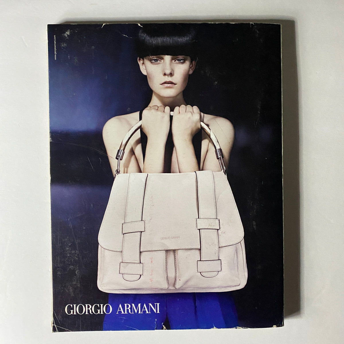 W Magazine March 2010 issue featuring a Giorgio Armani advertisement with a model displaying a designer handbag.