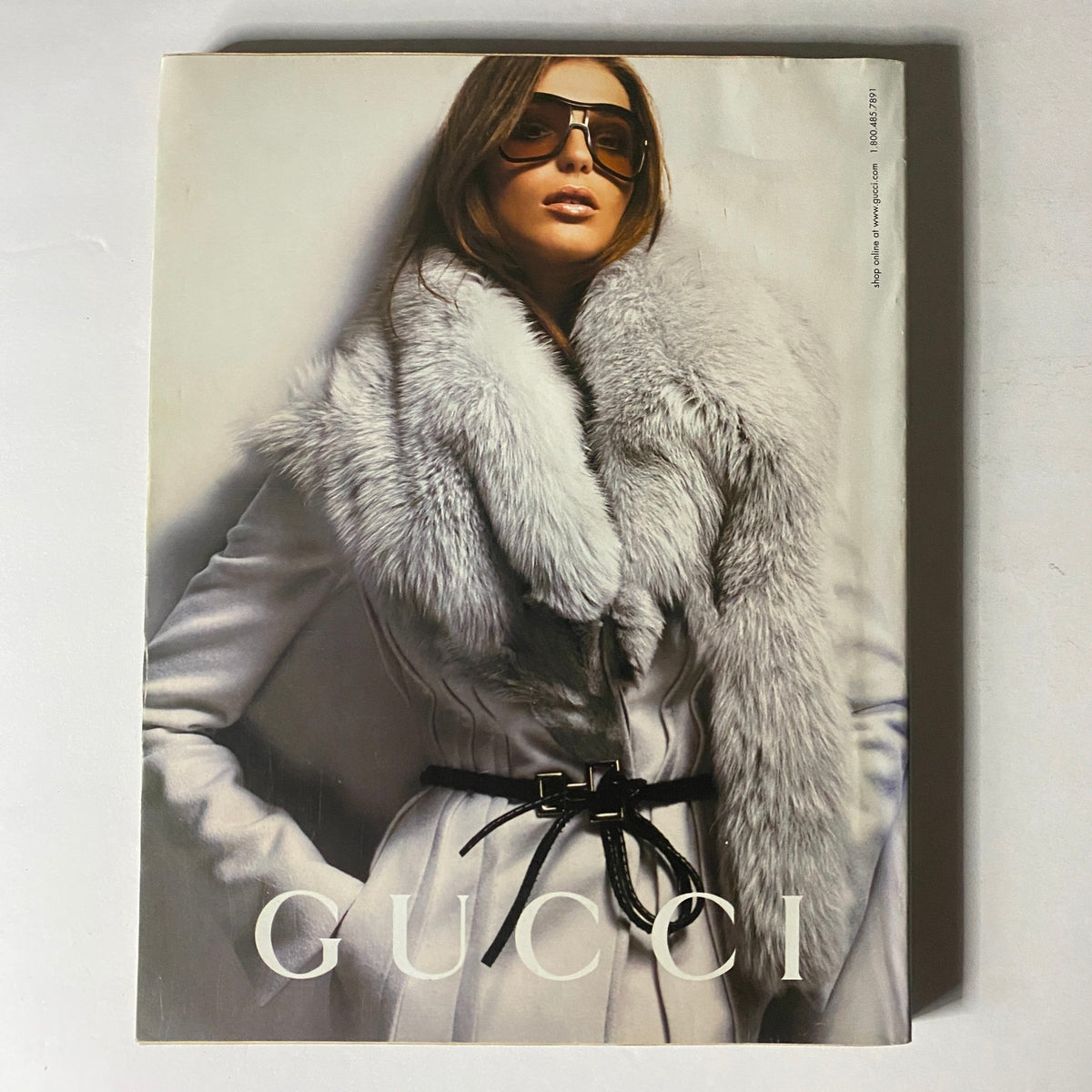 Gucci fashion model wearing chic sunglasses and a luxurious fur coat, exuding sophistication and style. W Magazine October 2004.