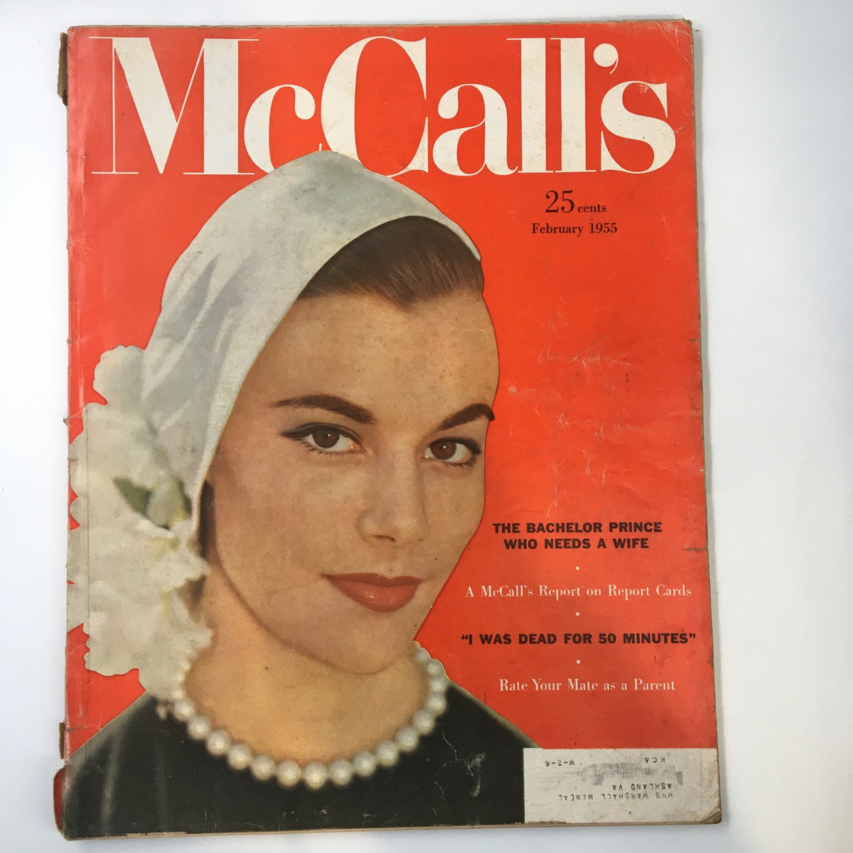 Cover of VTG McCall's Magazine February 1955 featuring the title 'The Bachelor Prince Who Needs a Wife', showcasing a woman with a pearl necklace and headscarf.