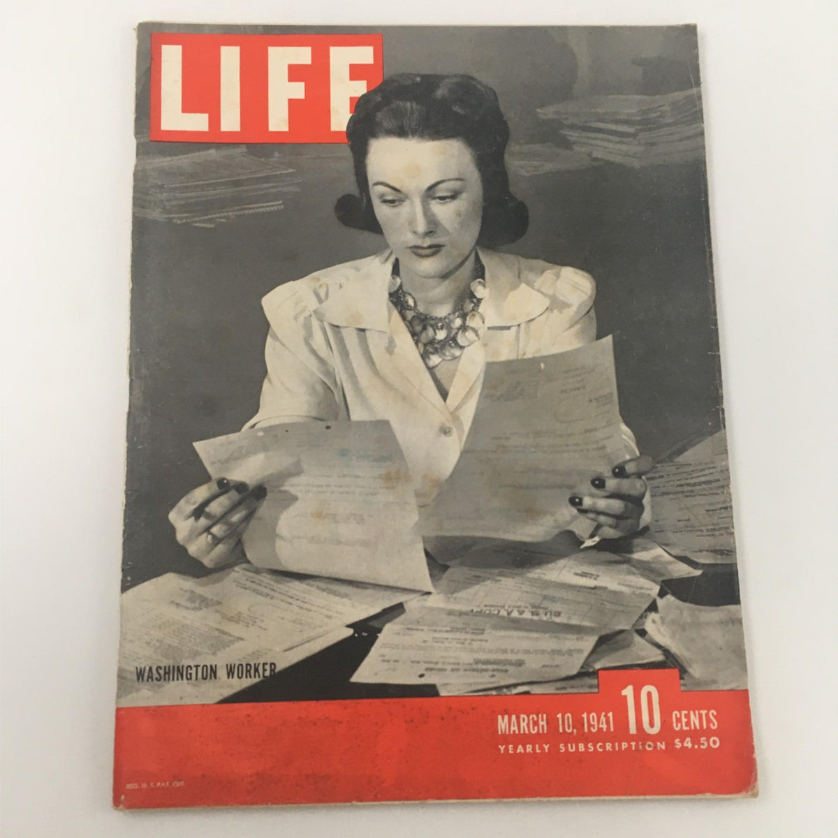 Vintage Life Magazine cover from March 10, 1941 featuring Washington Worker, Margaret Sharpe. The cover displays a woman in a white coat, surrounded by papers, embodying the essence of the era's socio-political landscape.