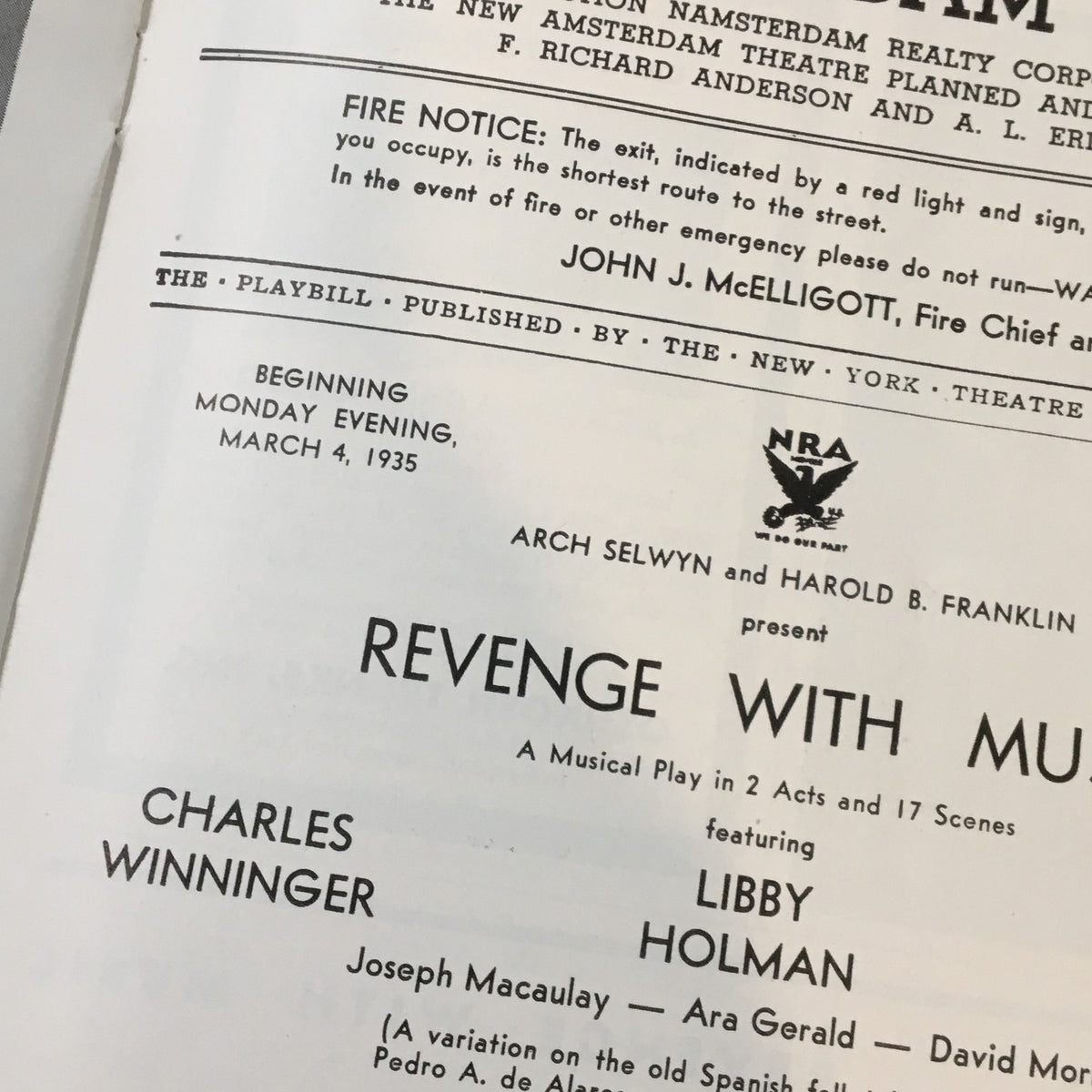 Close-up of the interior page of the 1935 Playbill from New Amsterdam Theatre, highlighting the title 'Revenge with Music' along with cast names including Libby Holman and Charles Winninger.