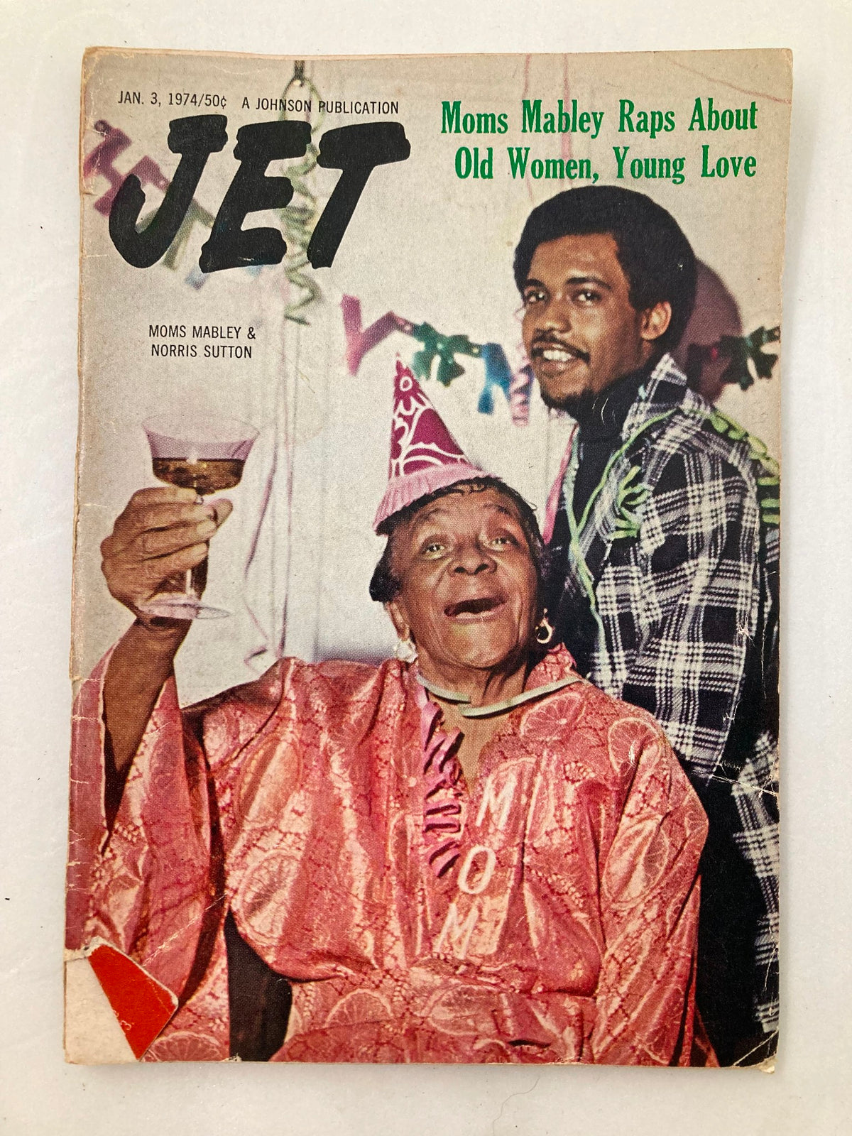 Cover of Jet Magazine, January 3, 1974, Volume 45, Number 15. Features Moms Mabley and Norris Sutton, celebrating with party hats and drinks, highlighting cultural significance in African American history.
