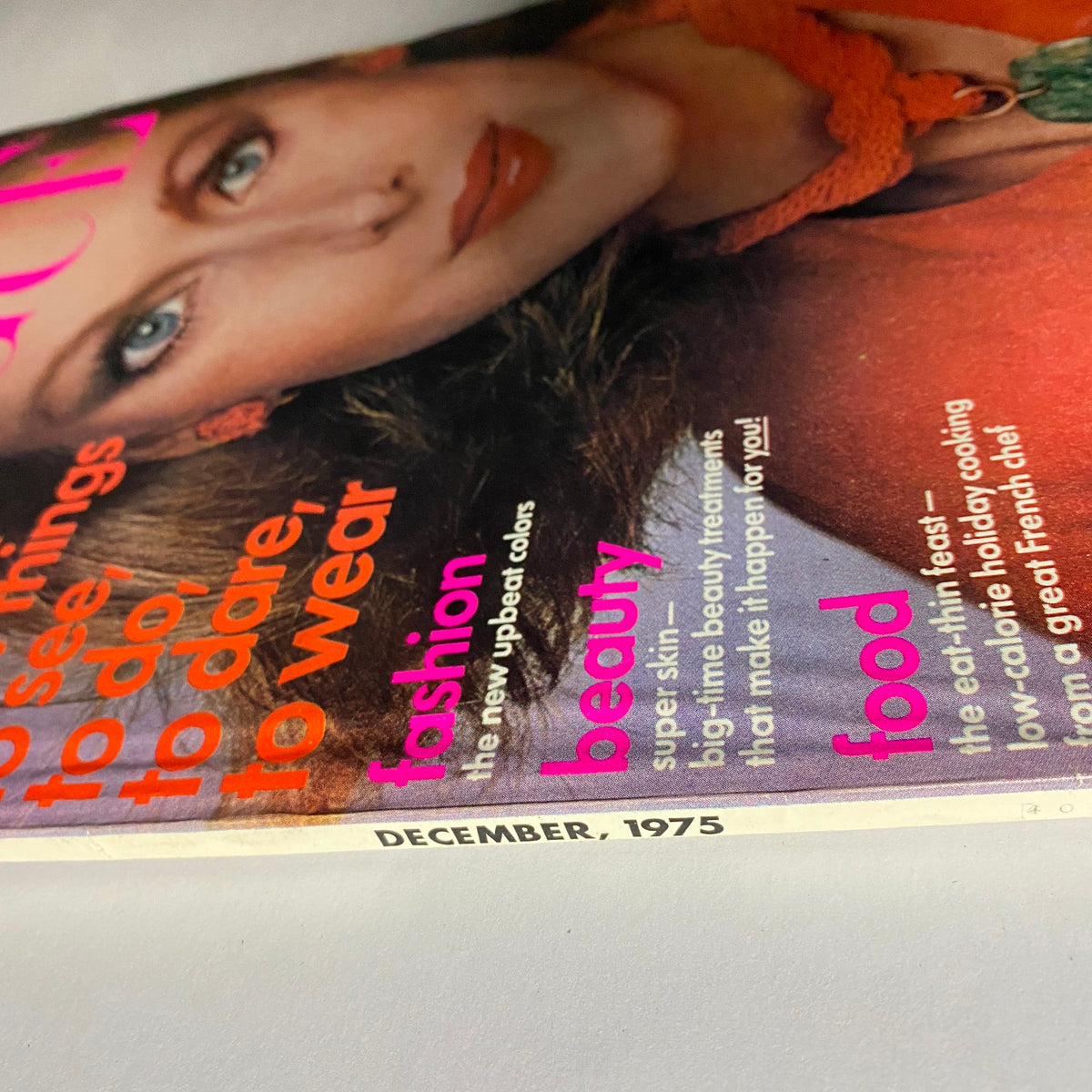 Close-up of the Vogue Magazine December 1975 cover featuring Karen Graham, emphasizing the magazine's title and key sections including fashion, beauty, and food. The date December 1975 is visible, marking this vintage issue as a collectible fashion artifact.