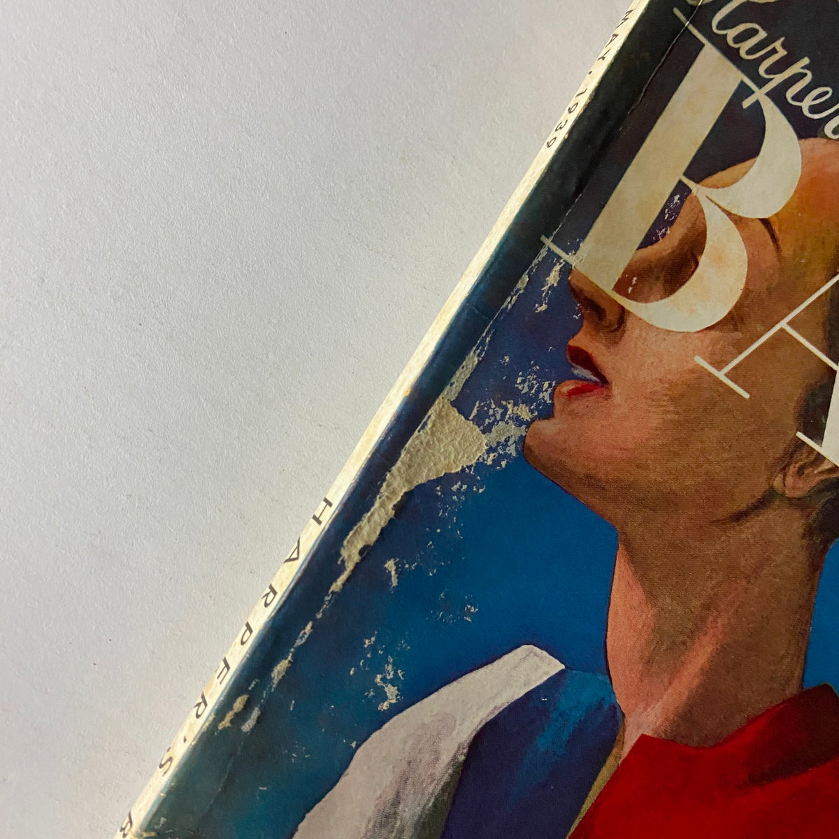 Close-up view of Harper's Bazaar Magazine May 1939 cover, highlighting details of the artistic depiction of a woman with a focus on vintage fashion elements.