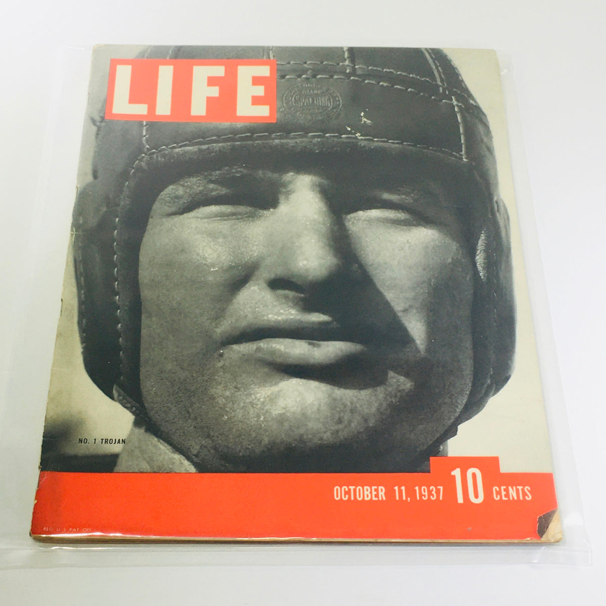 Vintage Life Magazine cover from October 11, 1937, featuring the No. 1 Trojan, showcasing a black and white photograph of a male figure wearing a helmet, with prominent text reading 'LIFE' and the date 'OCTOBER 11, 1937' with a price tag of '10 CENTS'.