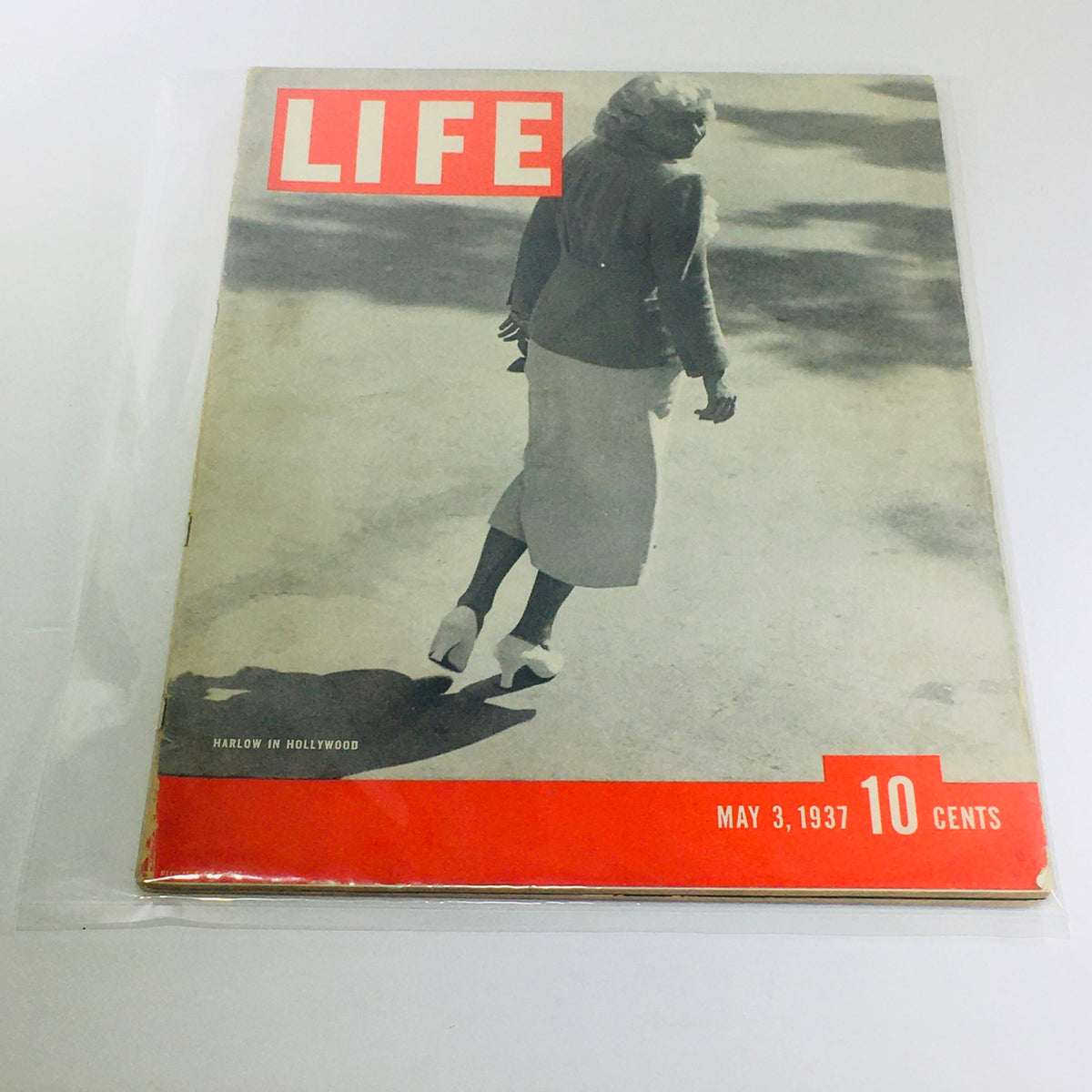 Vintage Life Magazine Cover from May 3, 1937 featuring the headline 'Harlow In Hollywood'. The magazine showcases a woman walking away, wearing a stylish outfit, with the iconic red 'LIFE' logo prominently displayed at the top.