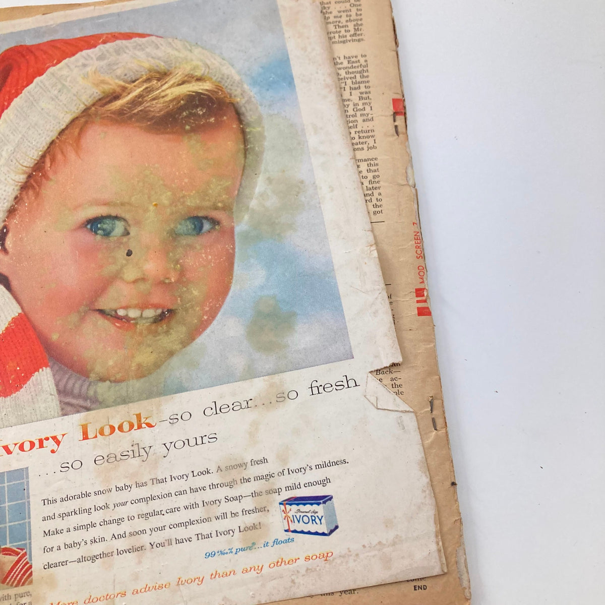 Vintage advertisement featuring a smiling baby in a red and white striped outfit and a Santa hat, from the December 1957 issue of VTG Modern Screen Magazine.