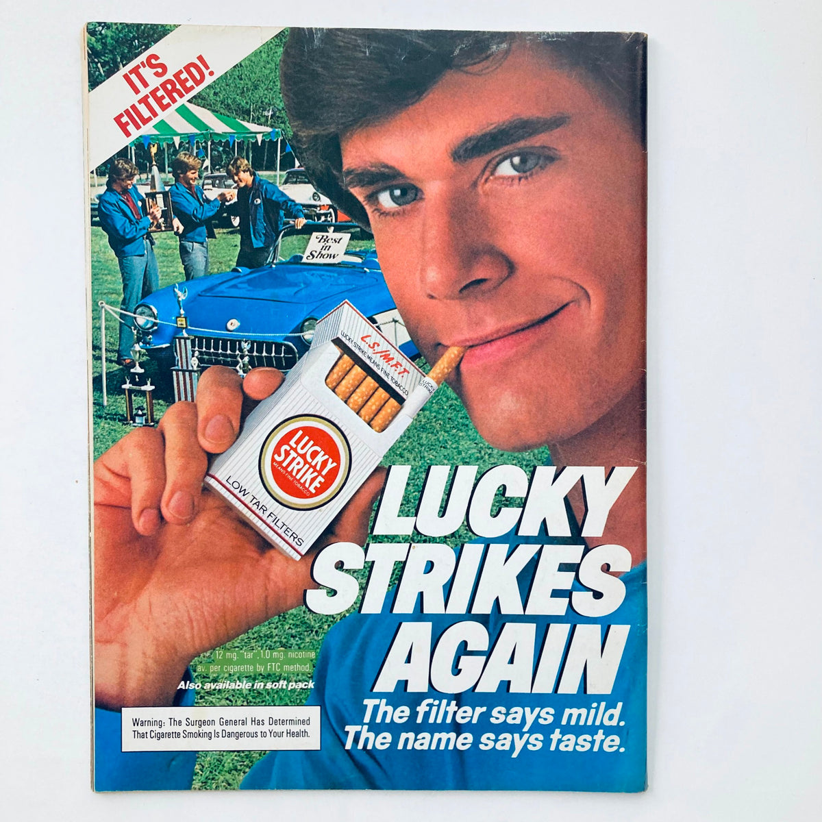 Cover of Vintage National Lampoon Magazine from April 1984, Vol 2 #69 depicting a young man smiling with a cigarette in his mouth, showcasing an advertisement for Lucky Strike cigarettes with the tagline 'Lucky Strikes Again' and a vintage car in the background.