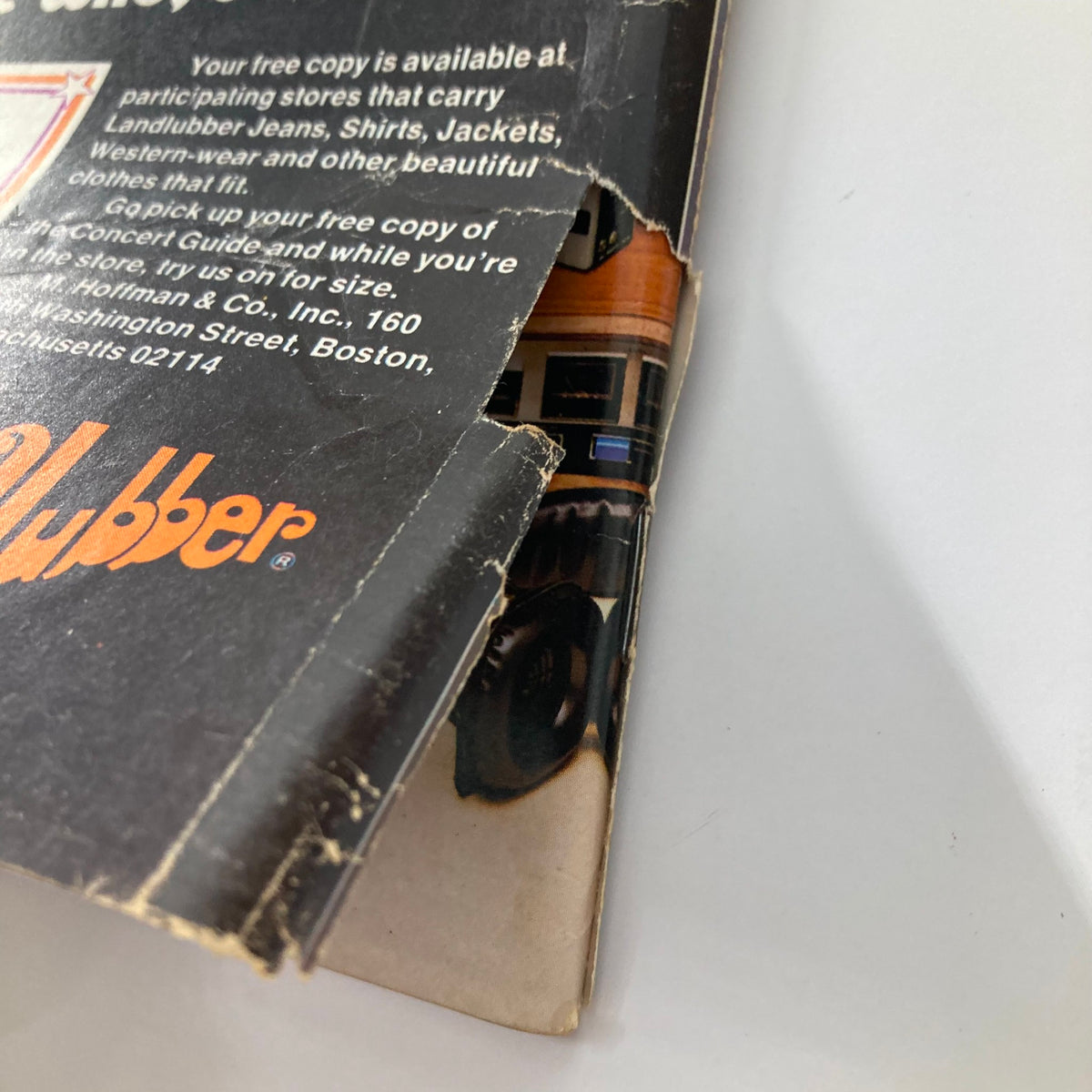 Close-up of the back cover of Vtg National Lampoon Magazine March 1974 showing a worn edge and part of the advertisement for Landlubber clothing, a nod to the vintage aesthetic.