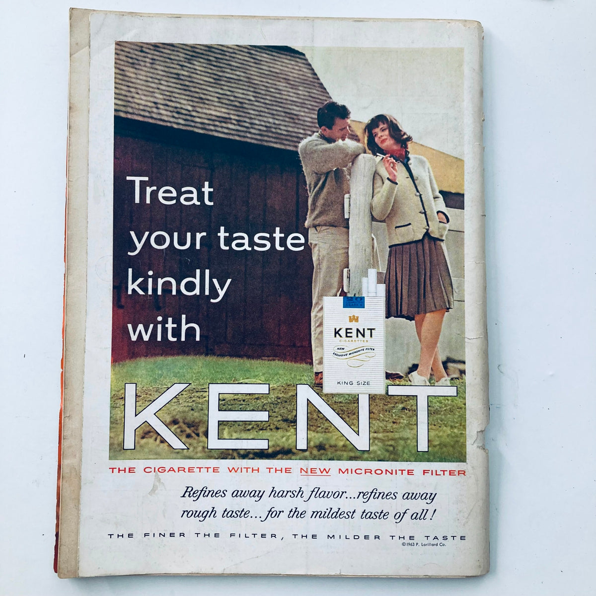 Vintage advertisement for Kent cigarettes from a Playboy magazine in February 1963, featuring a couple by a barn, highlighting mid-20th century marketing trends.