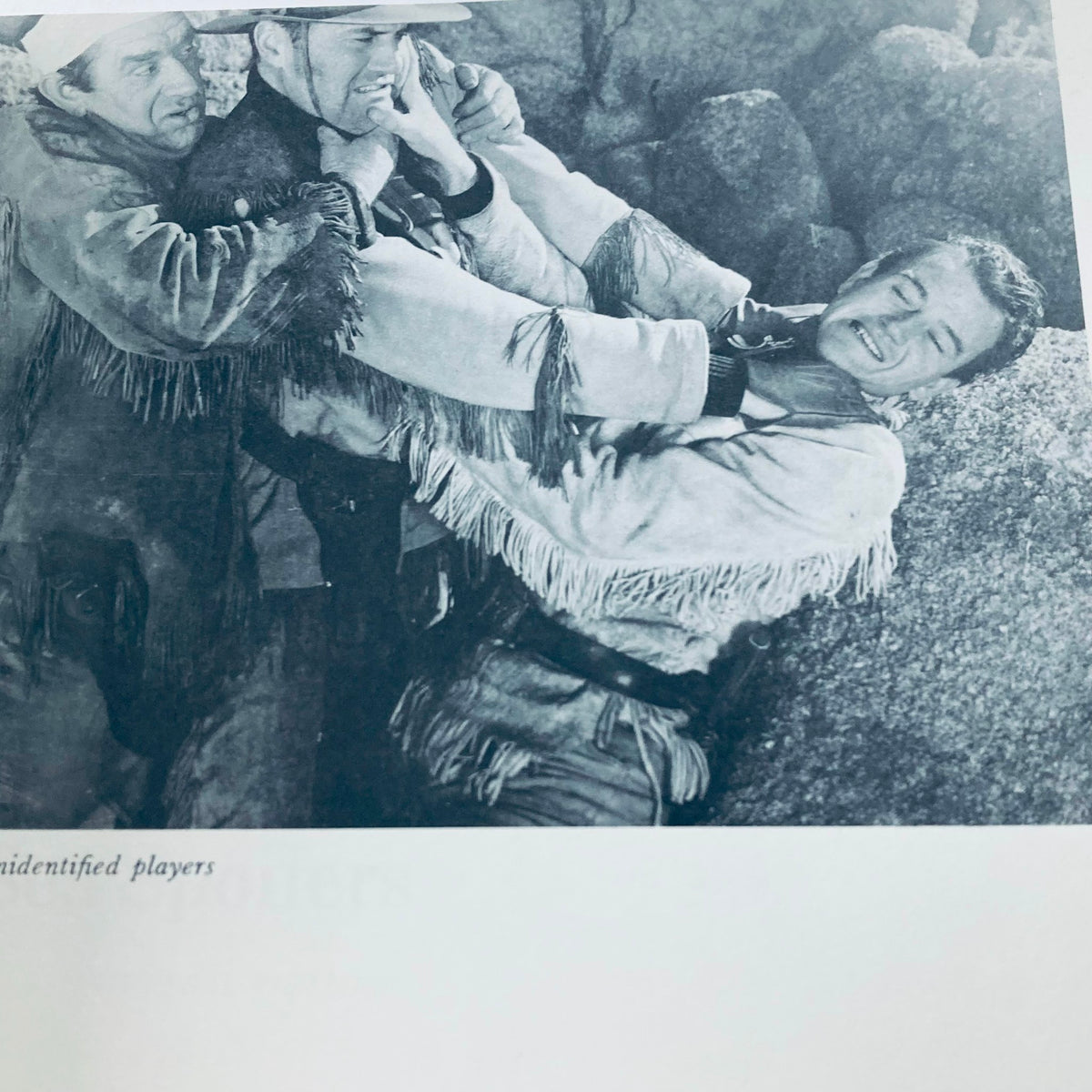 Black and white image from VTG 1976 The Films of John Wayne by Mark Ricci, Boris & Steve Zmijewsky, depicting a dramatic scene with unidentified actors.