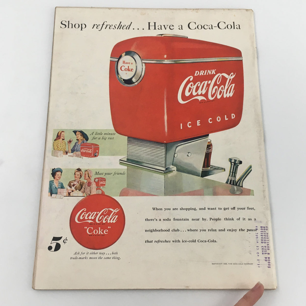 Vintage advertisement for Coca-Cola featured in a magazine, promoting a soda fountain with a red ice-cold Coca-Cola dispenser, representing 1940s American consumer culture.