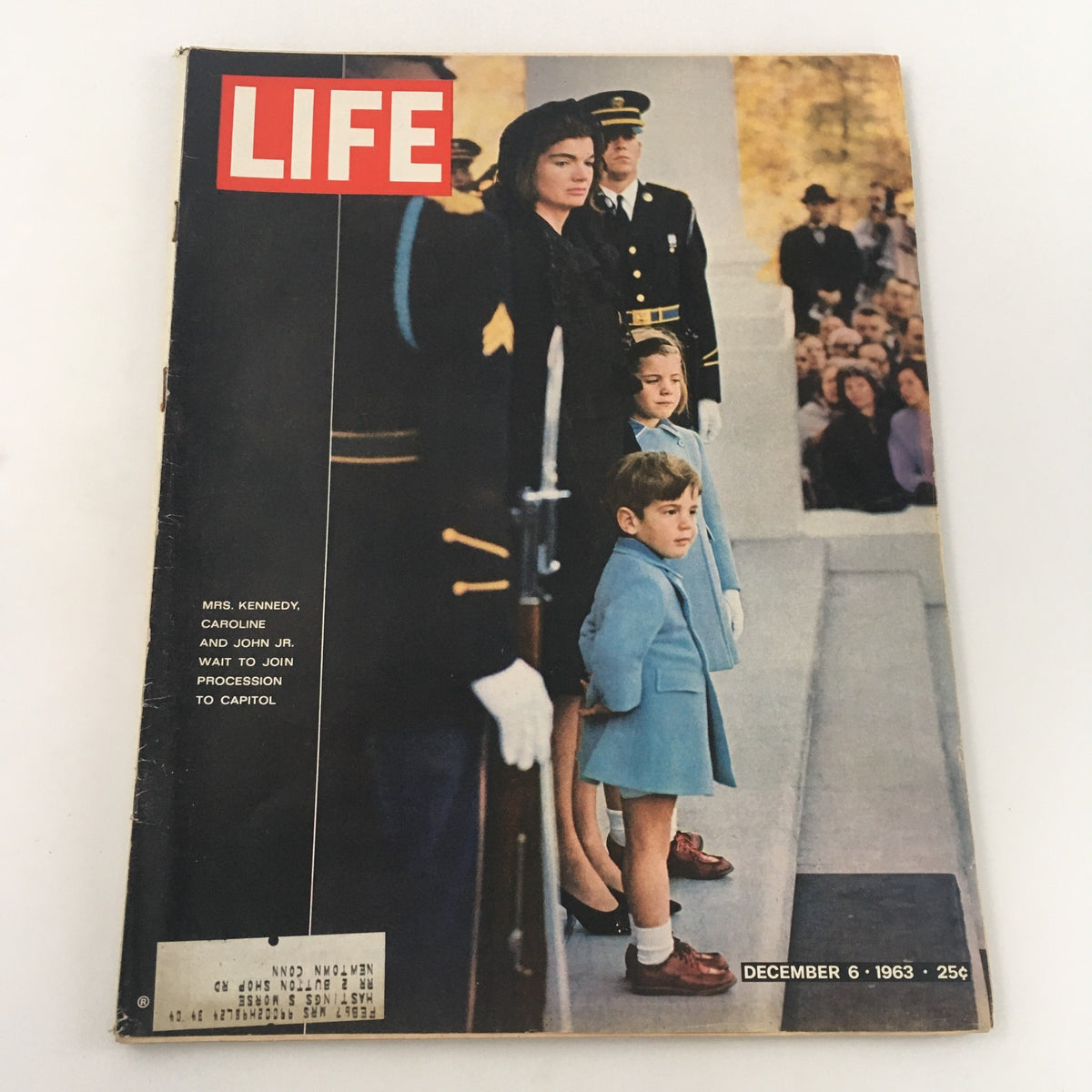 Vintage Life Magazine cover from December 6, 1963, featuring Mrs. Caroline Kennedy and John F. Kennedy Jr. waiting to join the procession to the Capitol. The image captures the essence of a pivotal moment in American history with a poignant photograph of the Kennedy family.