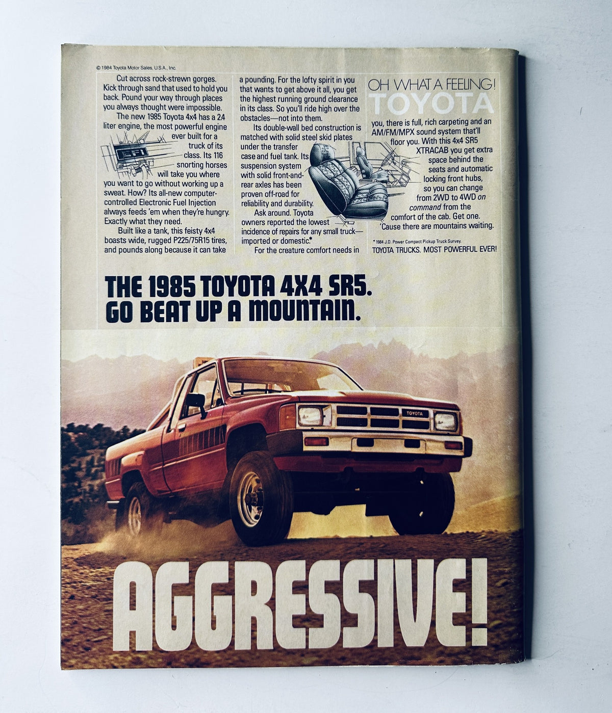Vintage advertisement for the 1985 Toyota 4x4 SR5 truck, featured in Sports Illustrated Magazine December 10, 1984. The ad captures an aggressive off-road vehicle designed for adventurous driving.