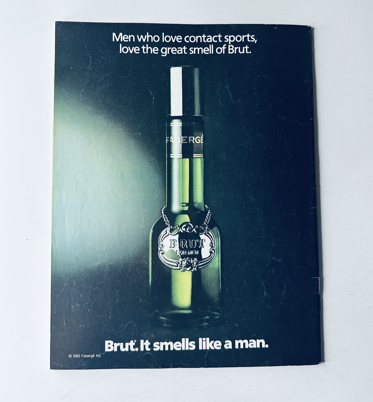 WWF Magazine February/March 1987 advertisement for Brut cologne, featuring a bottle of Brut with the tagline: 'Brut. It smells like a man.'