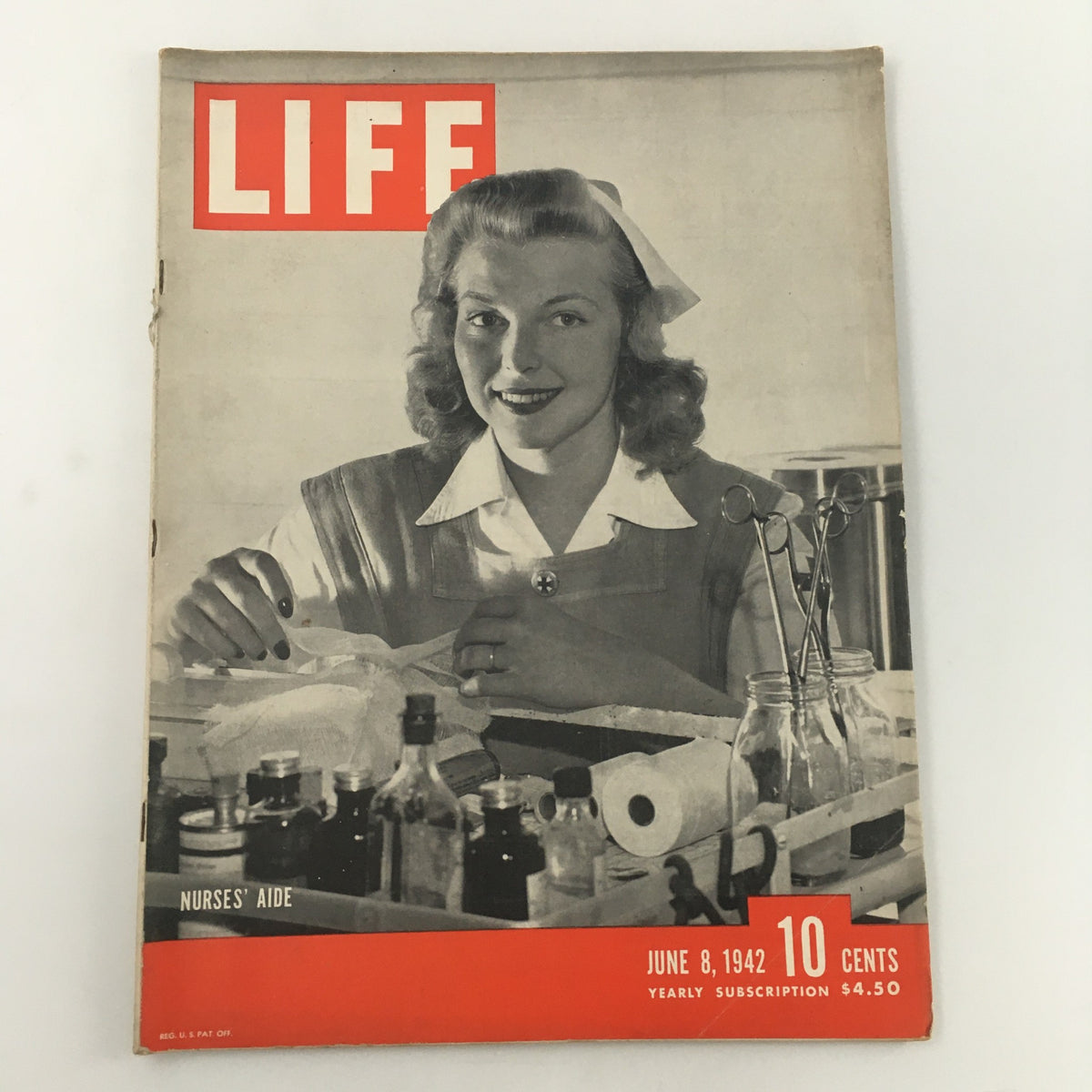 VTG Life Magazine June 8 1942 cover featuring a nurse's aide smiling, surrounded by medical supplies, showcasing the role of healthcare workers during World War II.