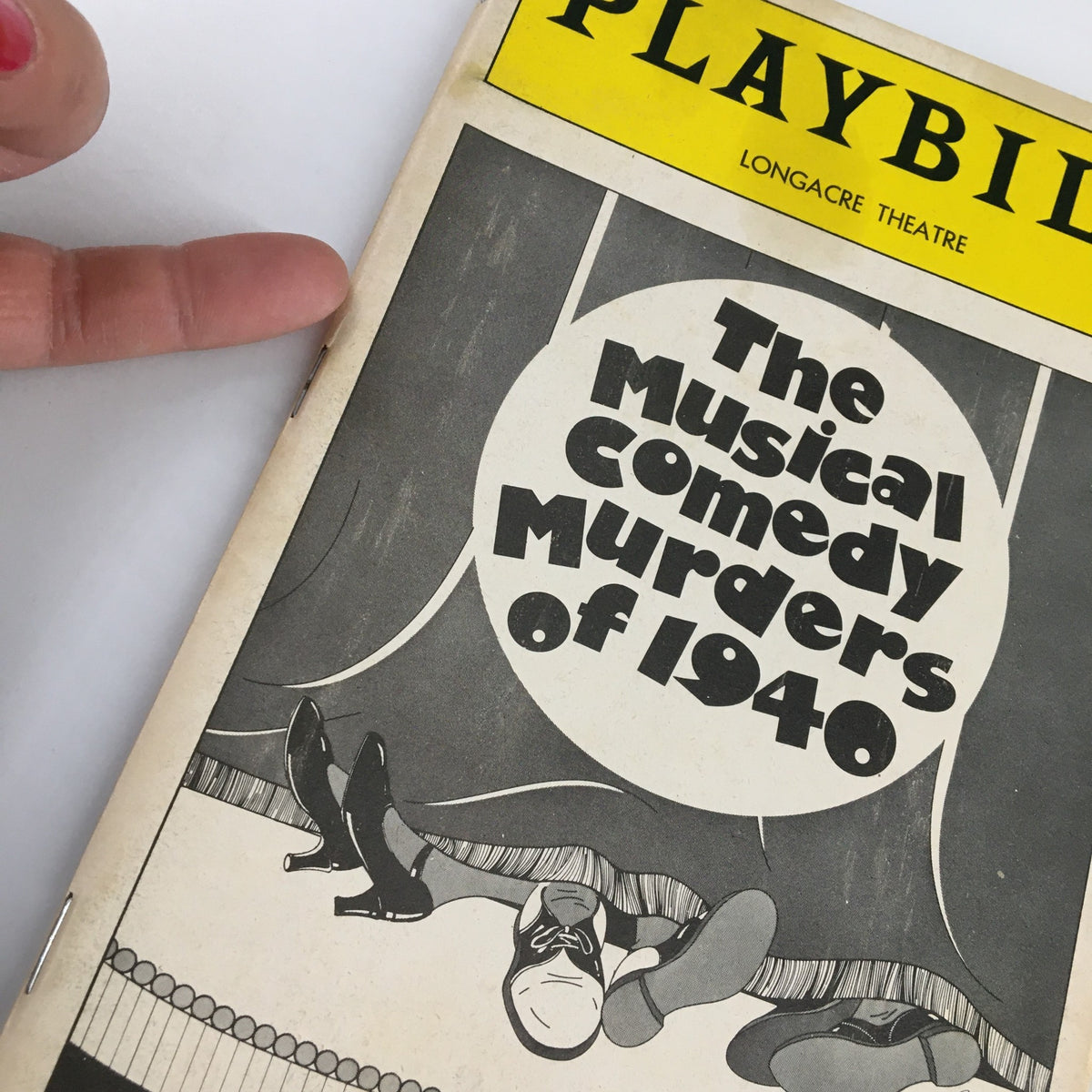 Close-up of the 1987 Playbill for The Musical Comedy Murders of 1940, showcasing the cover design and logo of the Longacre Theatre.