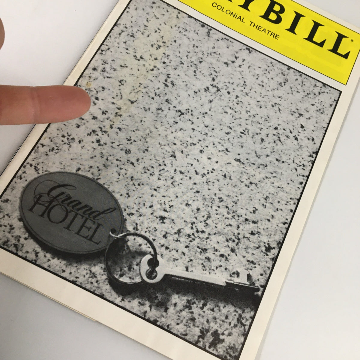 Close-up view of the 1989 Playbill for Grand Hotel from Colonial Theatre with detailed image of a key and hand pointing.