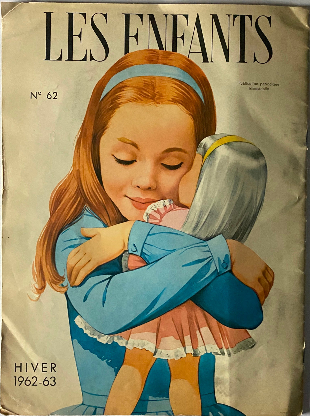 Cover of Les Enfants No. 62 Hiver 1962 - 1963 Catalog depicting a young girl in a blue dress hugging a doll. The illustration captures the nostalgic essence of 1960s children's fashion, appealing to collectors and vintage magazine enthusiasts.