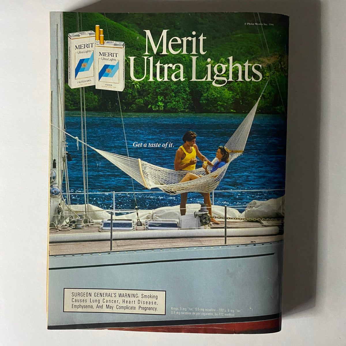 Merit Ultra Lights cigarette advertisement from the late 1980s, featuring a relaxing outdoor scene, included in Vogue Magazine October 1986 issue with Cindy Crawford cover.