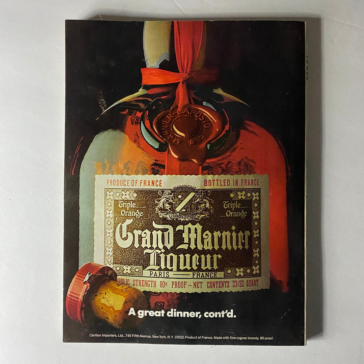 Advertisement for Grand Marnier liqueur, featuring a vintage bottle design, from Vogue Magazine February 1977.