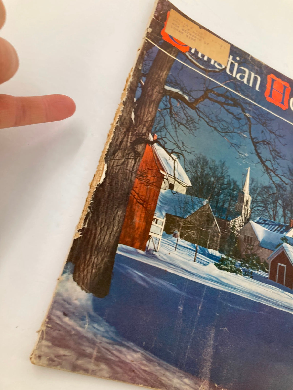 Side view of VTG Christian Herald Magazine January 1951 displaying the cover with a snowy scene. Emphasis on the magazine's age with visible wear and an address label on the cover.
