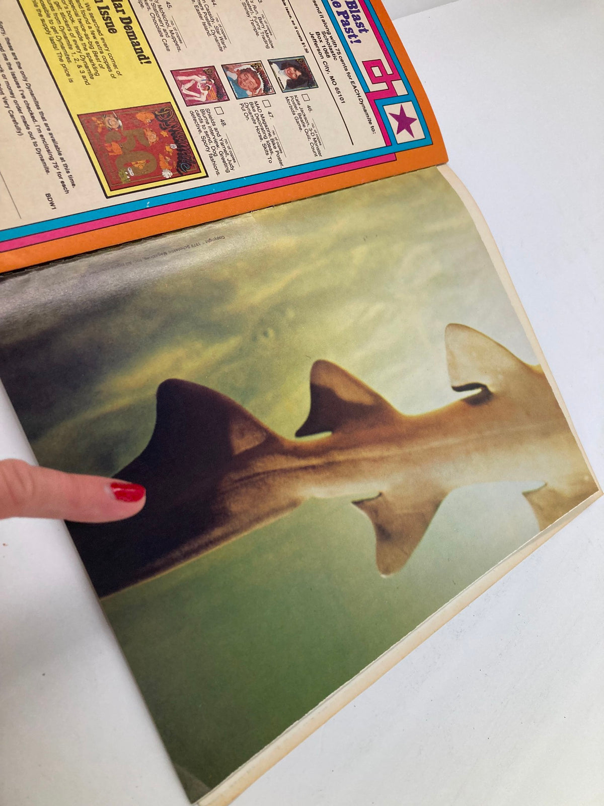 Interior page of VTG Dynamite Magazine No. 53 featuring a shark silhouette, with a finger pointing at the image, capturing the nostalgic essence of 1970s pop culture.