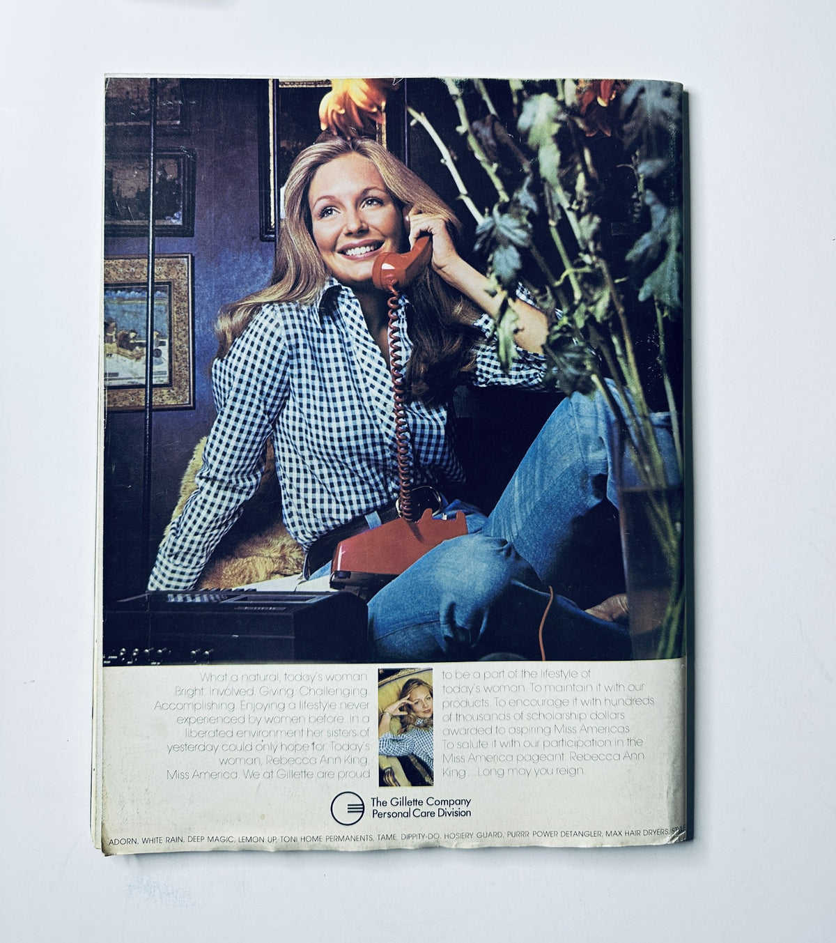 Back cover of Miss America Pageant Magazine September 2–8, 1974 featuring Rebecca Ann King sitting by a telephone in home attire, related to the lifestyle of the era.