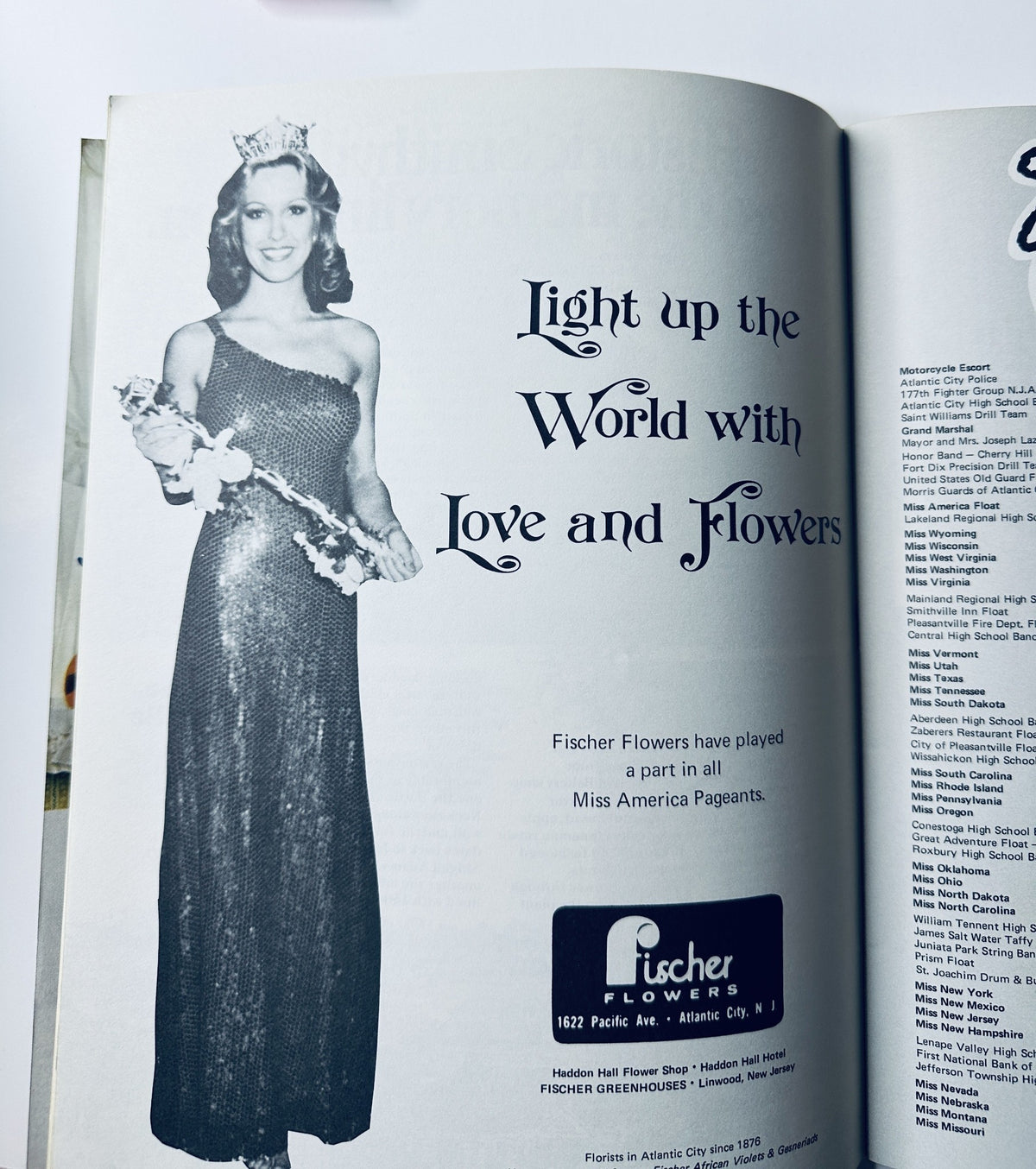 Advertisement in Miss America Pageant Magazine featuring a crowned contestant in a glamorous gown, promoting "Light up the World with Love and Flowers," from the September 5-11, 1977 issue.