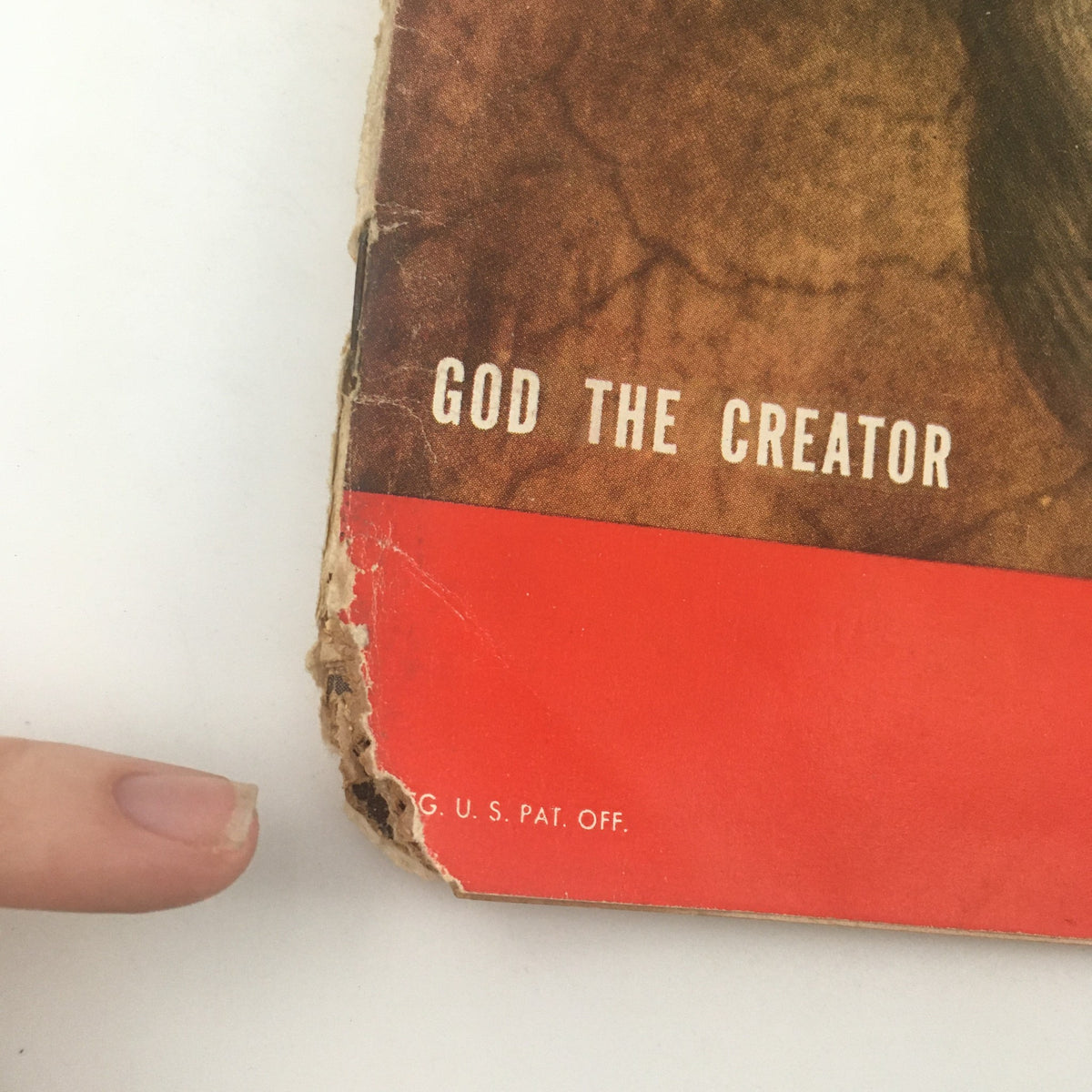 Close-up of VTG Life Magazine December 26 1949, showing damage with the text 'God the Creator' and highlighting wear on the vintage magazine.