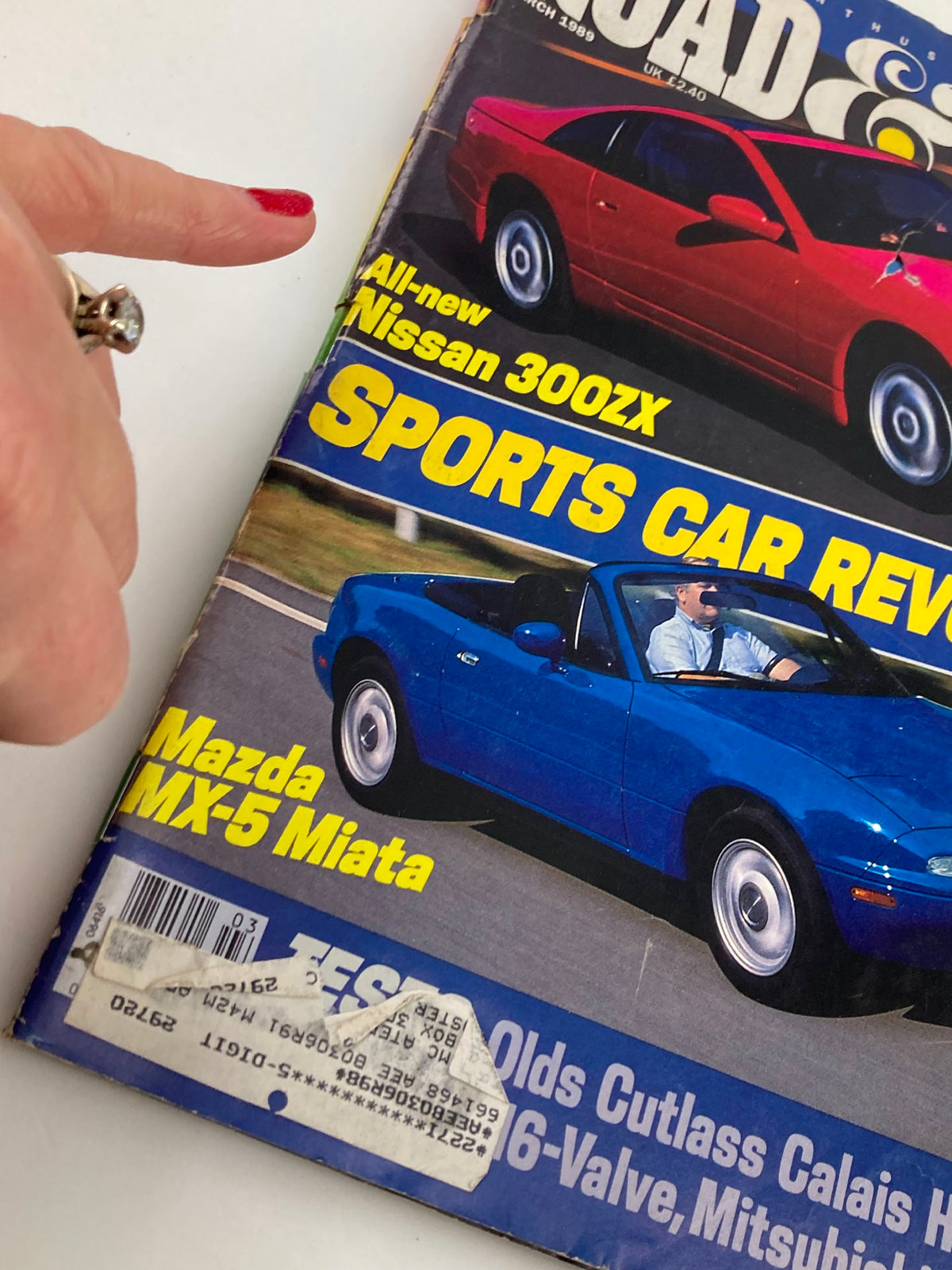 Close-up of the cover of VTG Road & Track Magazine March 1989, showcasing the Nissan 300ZX and Mazda MX-5 Miata with a finger pointing at the text.
