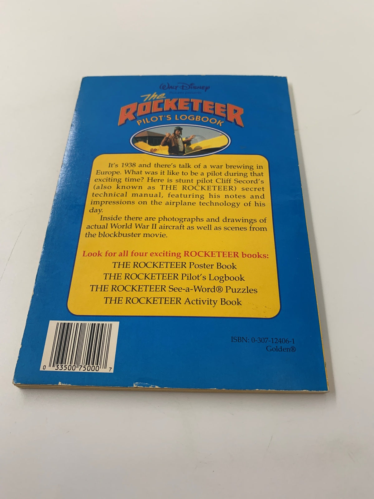 Back cover of Walt Disney The Rocketeer Pilot's Logbook displaying a description of the manual, featuring Cliff Secord and highlighting vintage aircraft information and related Rocketeer books.