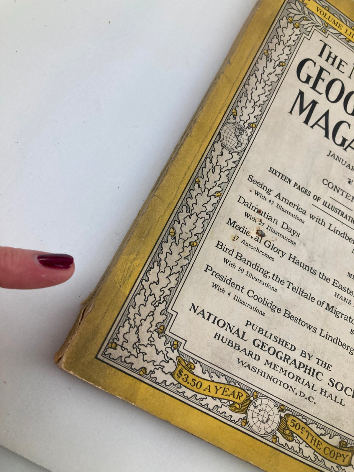 Close-up of the binding and corner of the National Geographic Magazine January 1928 featuring Charles Lindbergh, showcasing wear consistent with age.
