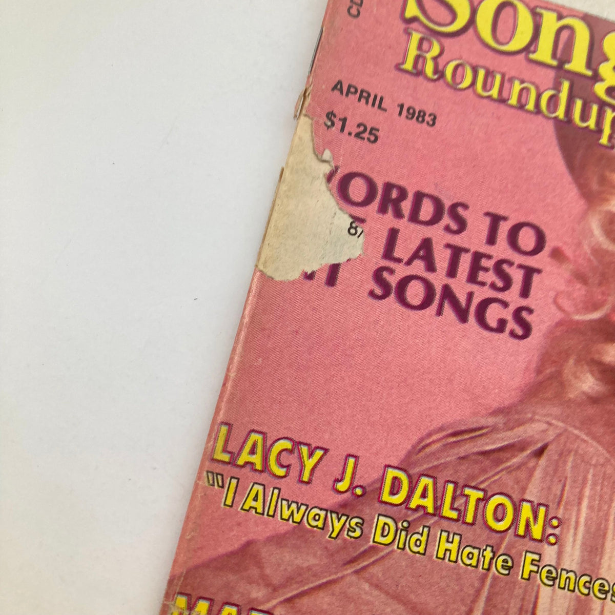 Close-up of the April 1983 issue of VTG Country Song Roundup Magazine, highlighting the magazine's title and featured articles, including Lacy J. Dalton and Marty Robbins.