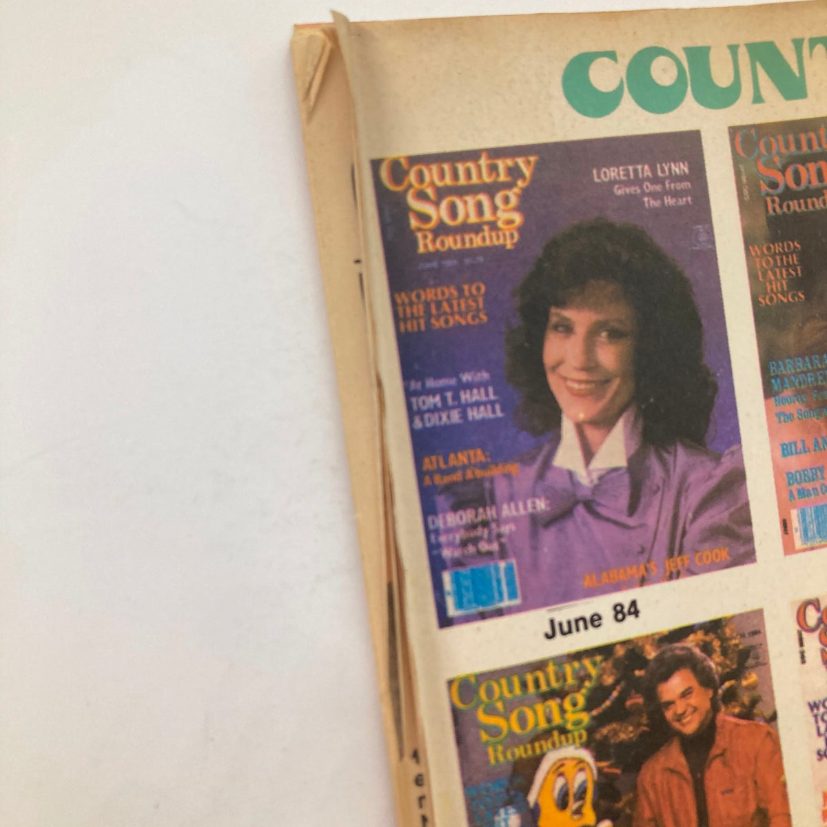 Cover of Country Song Roundup magazine featuring the title and various artists from the country music scene, showcasing elements of vintage design from the 1980s.