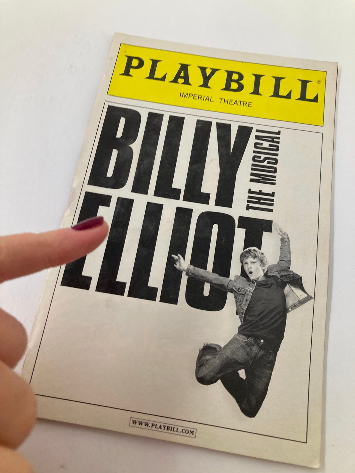 2010 Playbill from Billy Elliot The Musical at Imperial Theatre, with a close-up view highlighting the title and an individual pointing at it.