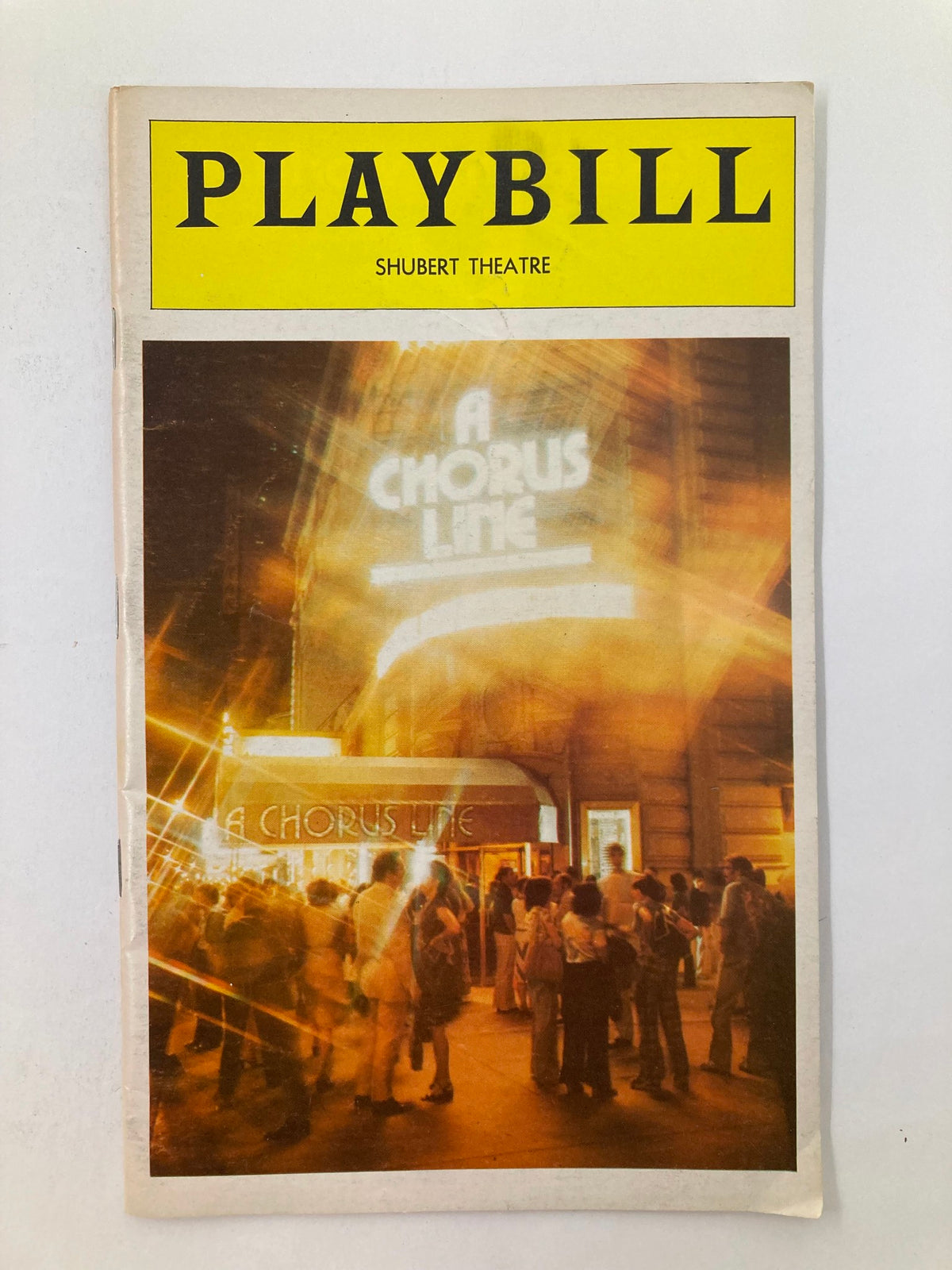 1979 Playbill titled 'A Chorus Line' from Sam S. Shubert Theatre, featuring an illuminated theater marquee and crowd outside the venue.