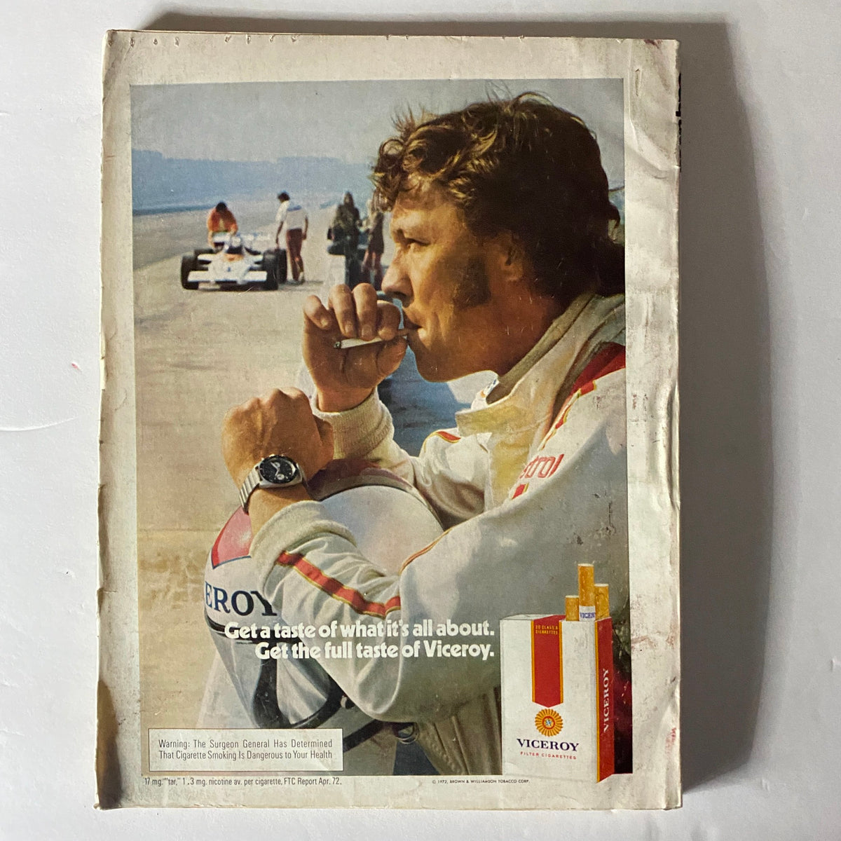 Illustration for Viceroy cigarette advertisement featuring a man in racing gear, contemplating with a cigarette, from Esquire Magazine October 1972: The Impotence Boom, reflecting the era's marketing styles.