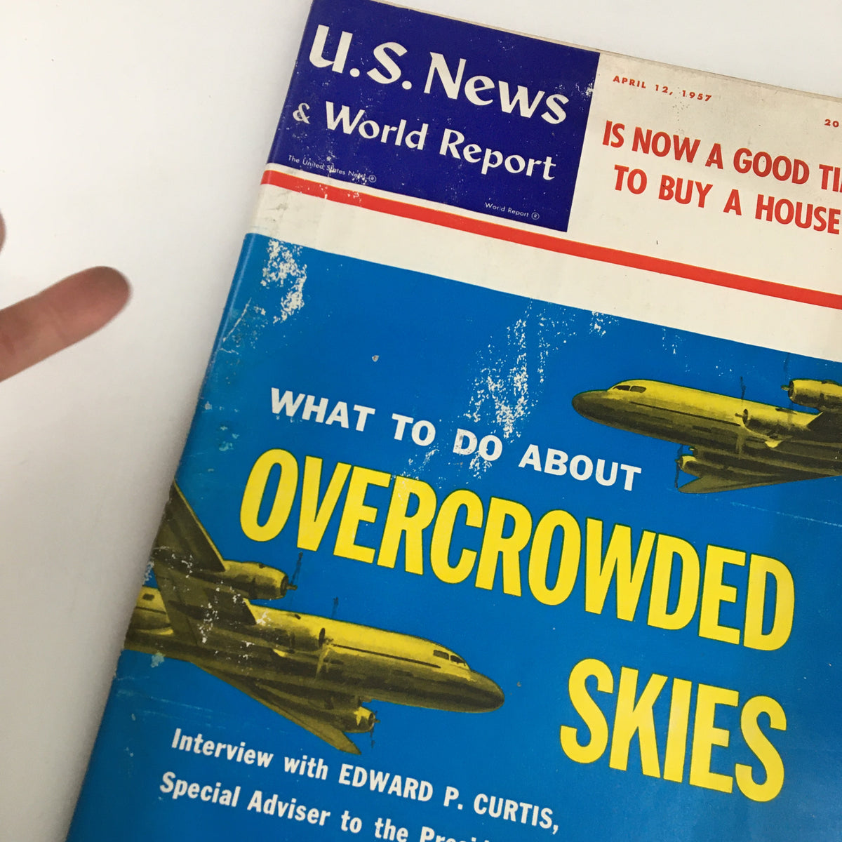 Cover of US News & World Report Magazine from April 12, 1957, featuring an interview with Edward P. Curtis, showcasing vintage design elements and topic on overcrowded skies.