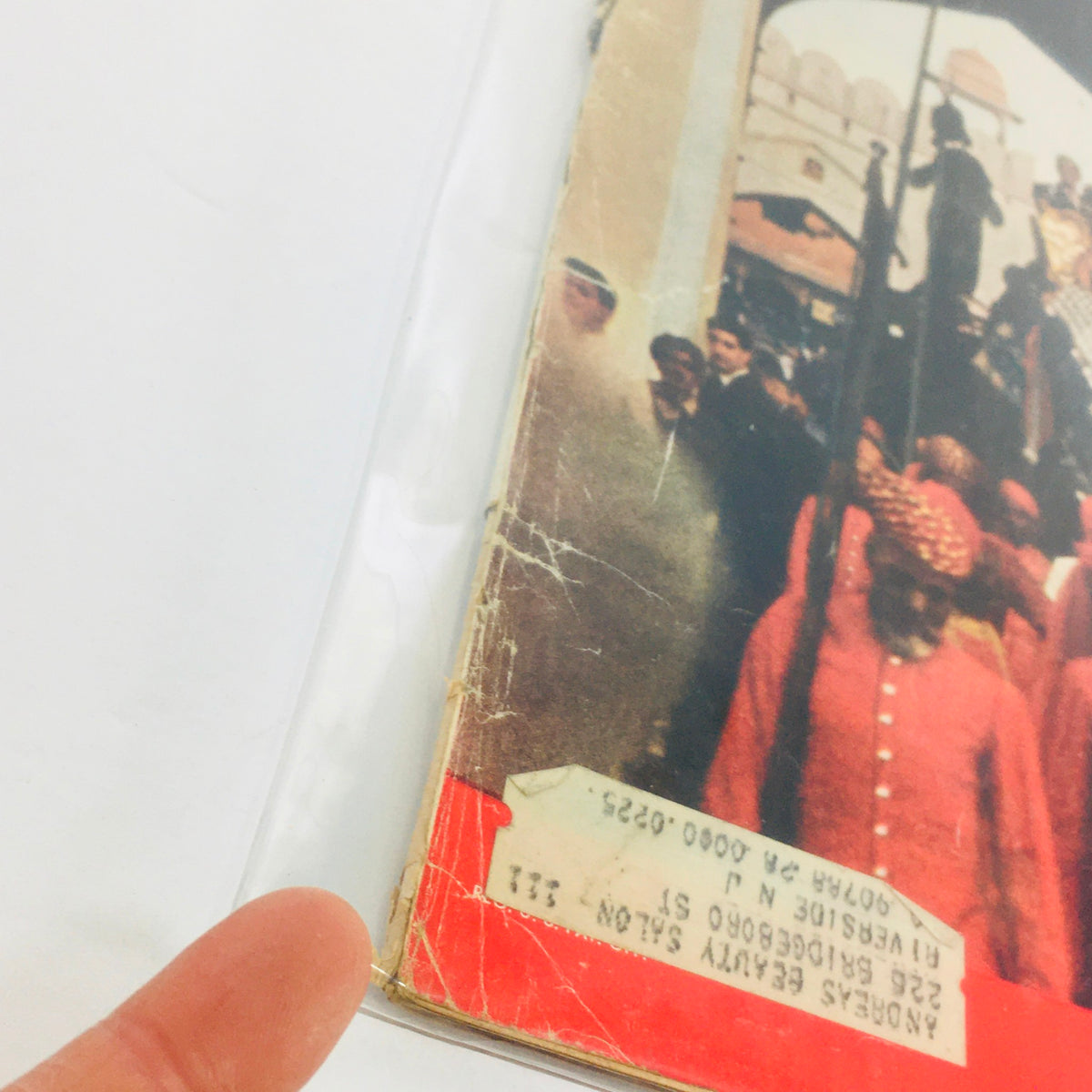 Close-up of the vintage Life Magazine from February 3, 1961, featuring a worn cover showing Queen Elizabeth II's Grandest Tour in India, showcasing a glimpse of historical significance with visible wear and an address label.
