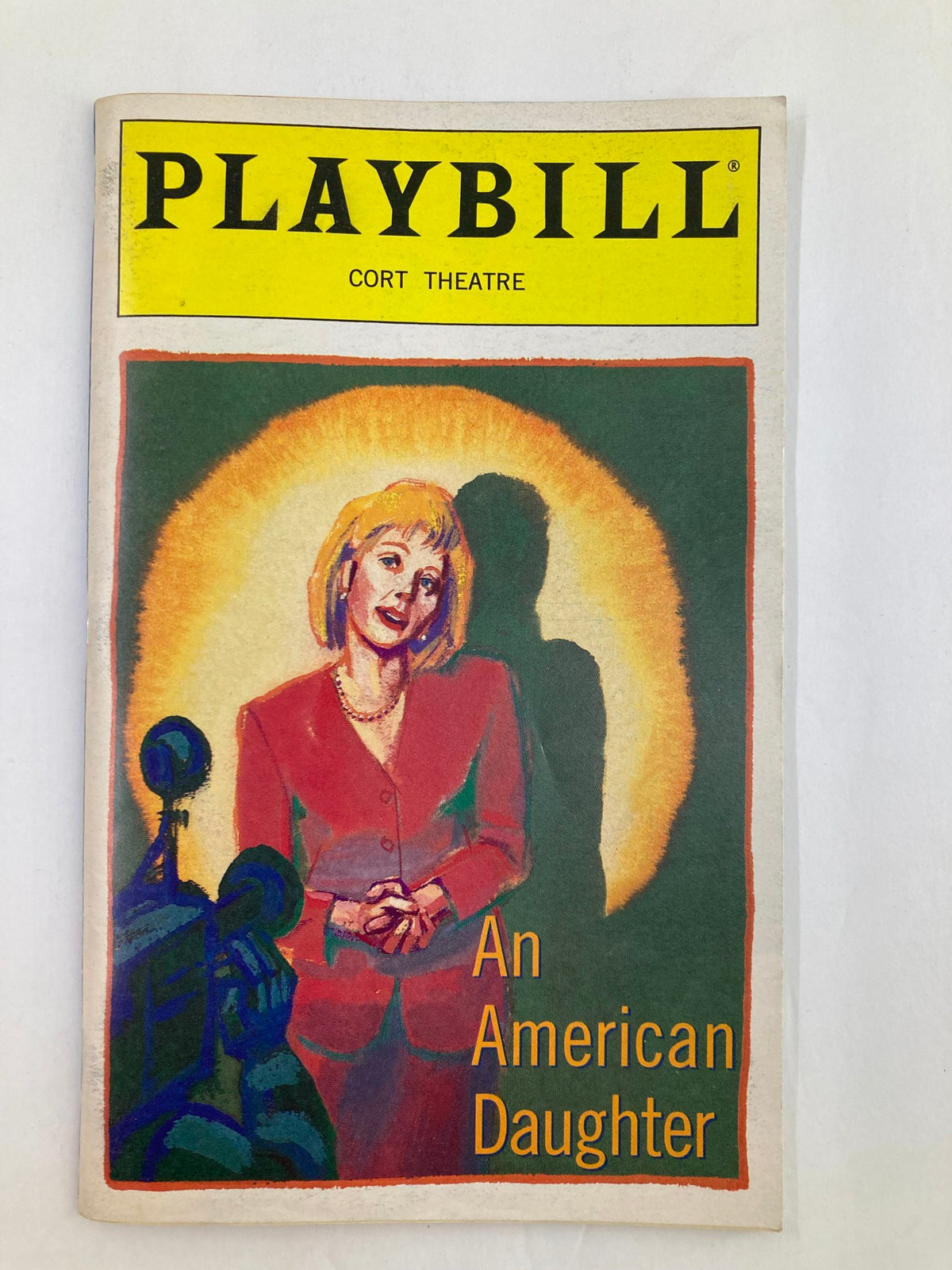 Front cover of the 1997 Playbill for 'An American Daughter' at Cort Theatre featuring a portrait of a woman in a red suit against a glowing background.