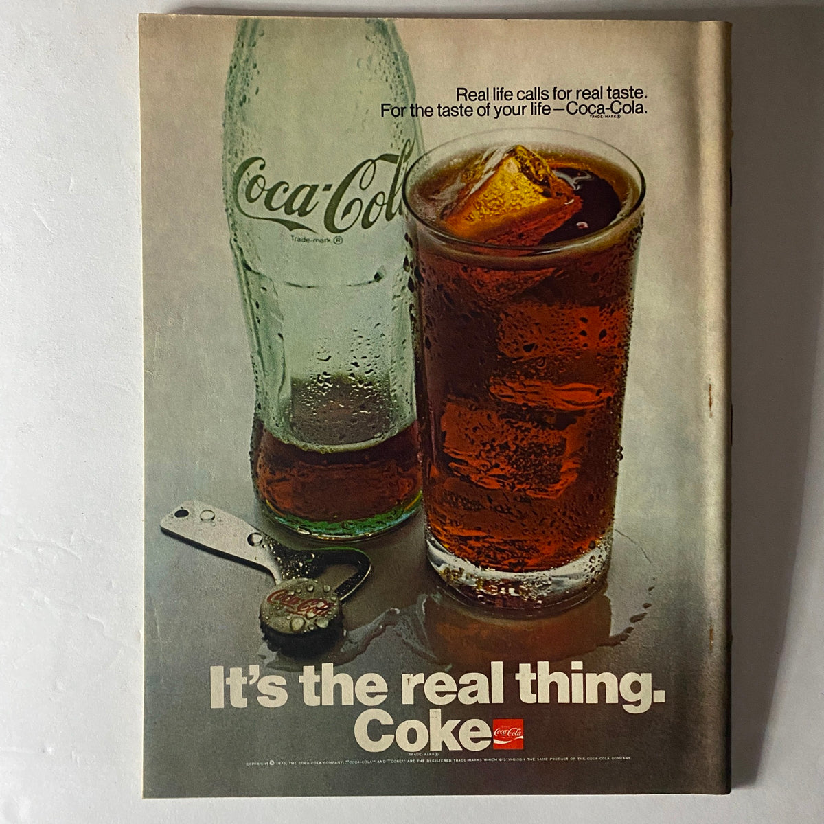 Vintage Coca-Cola advertisement from April 1970 issue of American Girl Magazine highlighting the drink with a refreshing image of a Coke bottle and glass.