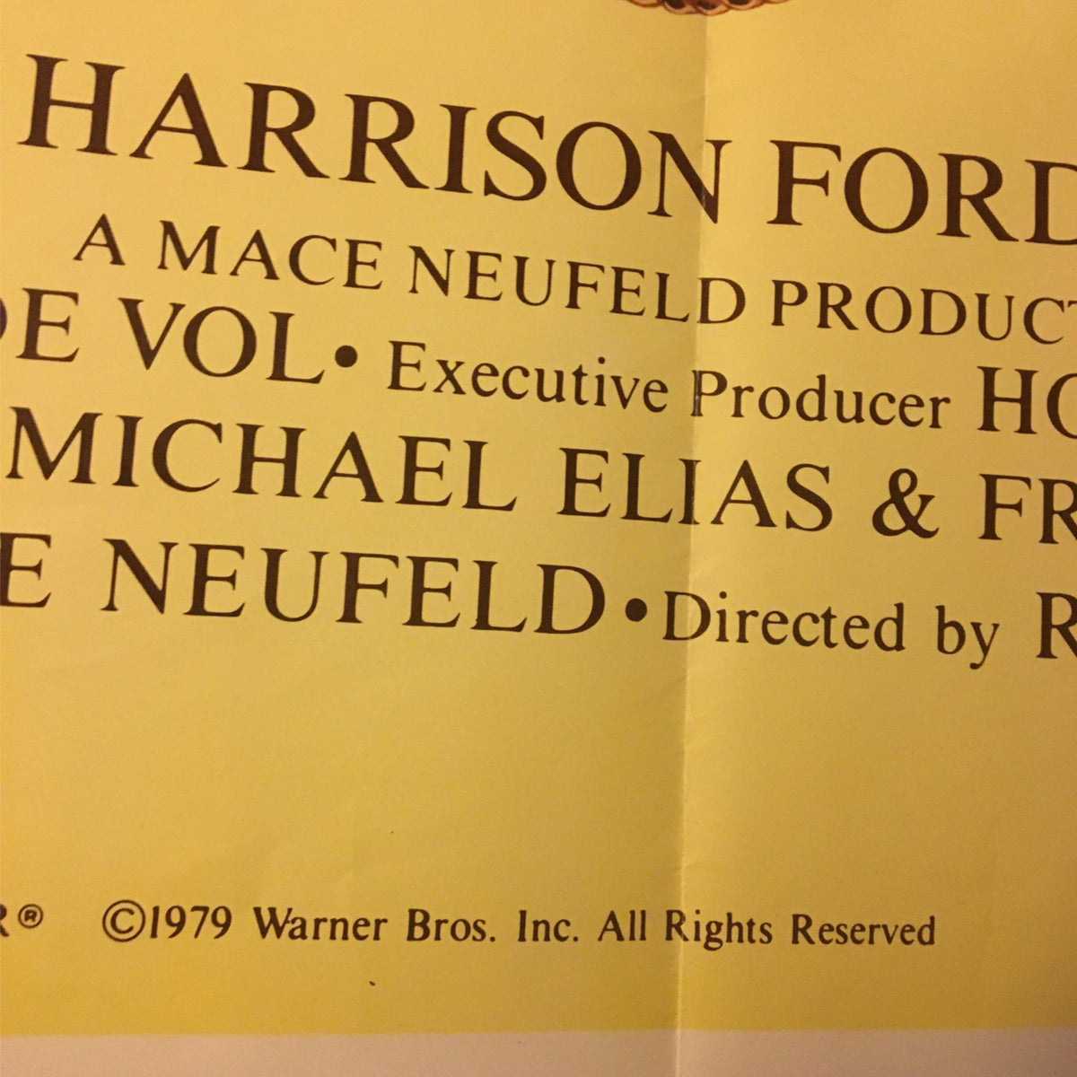 Detail of the 1979 The Frisco Kid Movie Poster, showing credits including Harrison Ford's name and production details, set against a yellow background.