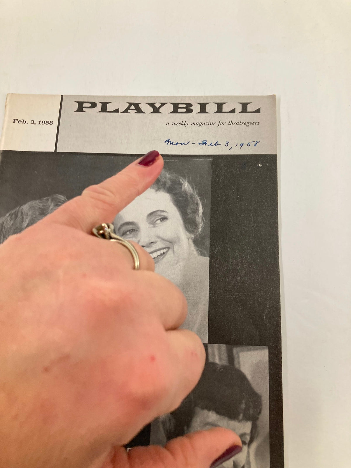 Close-up of the 1958 Playbill for 'The Dark at the Top of the Stairs' with a hand pointing at the title, revealing details of this iconic Broadway performance.