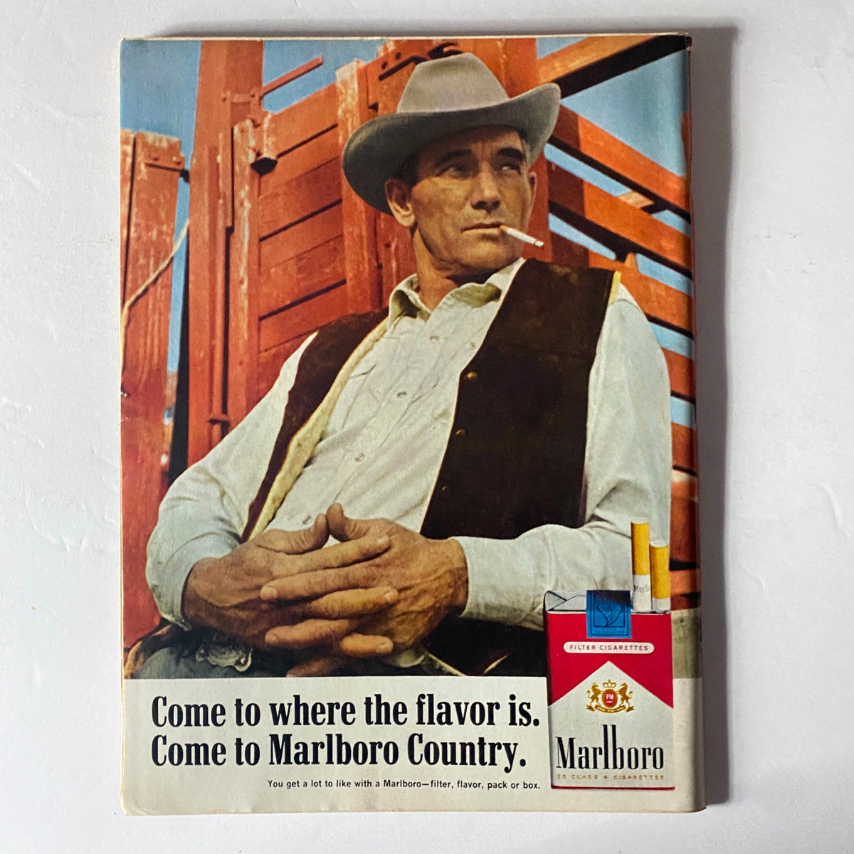 Marlboro advertisement featuring a rugged cowboy relaxing with a cigarette, promoting the slogan 'Come to Marlboro Country'.